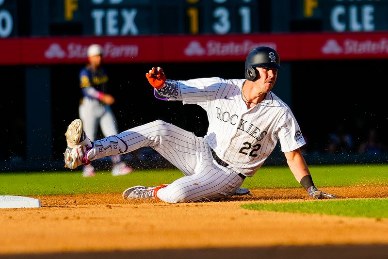 Jul 4, 2024; Denver, Colorado, USA; Colorado Rockies left fielder Nolan Jones (22) slides into second base against the Milwaukee Brewers during the fourth inning at Coors Field. Mandatory Credit: Troy Babbitt-USA TODAY Sports

 