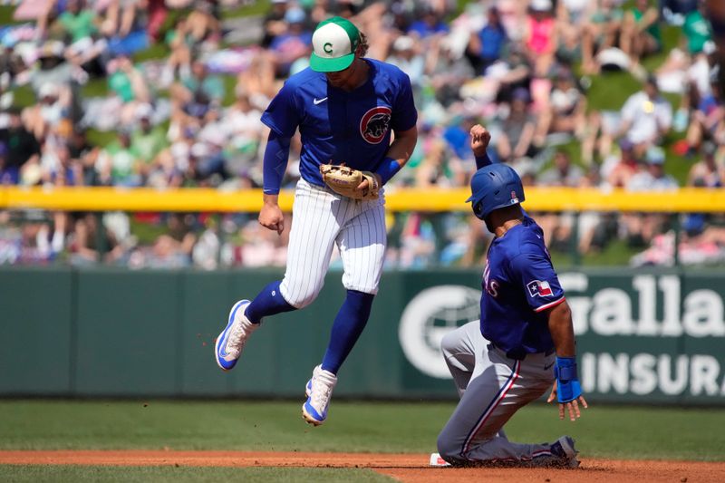 Mar 17, 2024; Mesa, Arizona, USA; Chicago Cubs shortstop Dansby Swanson (7) gets the force out Texas Rangers second baseman Marcus Semien (2) in the first inning at Sloan Park. Mandatory Credit: Rick Scuteri-USA TODAY Sports