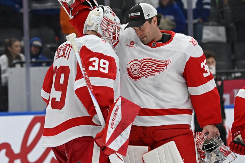 Oct 13, 2025; Toronto, Ontario, CAN; Detroit Red Wings goalie John Gibson (36) celebrates the victory over the Toronto Maple Leafs with goalie Cameron Talbot (39) at Scotiabank Arena. Mandatory Credit: Gerry Angus-Imagn Images
