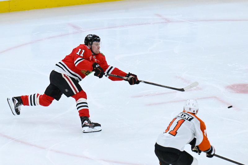 Dec 23, 2025; Chicago, Illinois, USA;  Chicago Blackhawks center Oliver Moore (11) shoots against Philadelphia Flyers right wing Travis Konecny (11) during the second period at United Center. Mandatory Credit: Matt Marton-Imagn Images