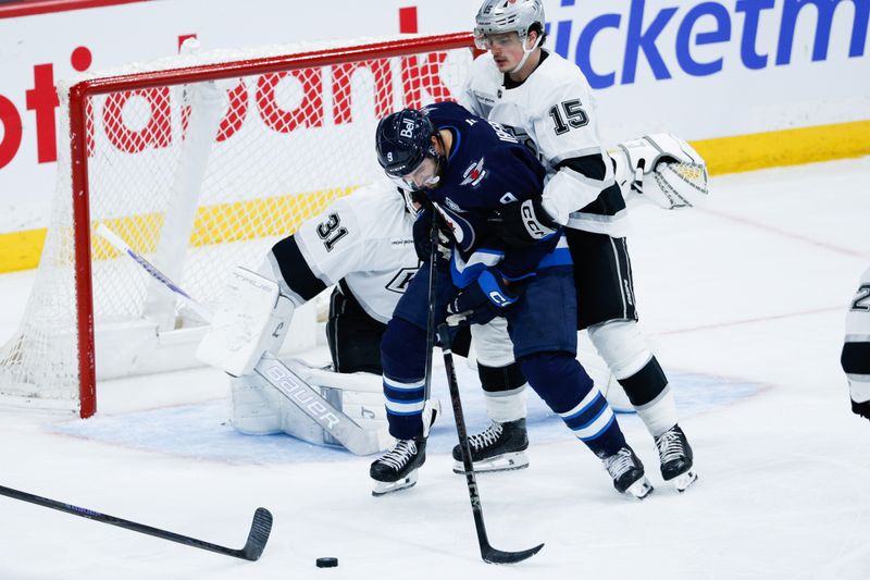 Jan 9, 2026; Winnipeg, Manitoba, CAN; Winnipeg Jets forward Alex Iafallo (9) and Los Angeles Kings forward Alex Turcotte (15) search for the puck during the third period at Canada Life Centre. Mandatory Credit: Terrence Lee-Imagn Images