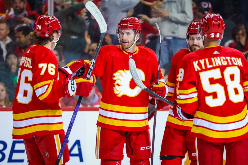 Apr 18, 2024; Calgary, Alberta, CAN; Calgary Flames center Kevin Rooney (21) celebrates his goal with teammates against the San Jose Sharks during the second period at Scotiabank Saddledome. Mandatory Credit: Sergei Belski-USA TODAY Sports