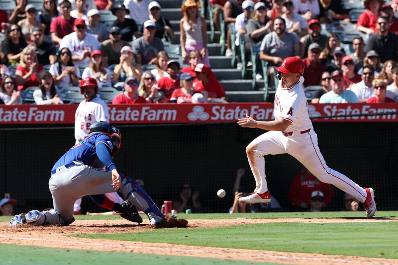 Sep 29, 2024; Anaheim, California, USA; Los Angeles Angels catcher Matt Thaiss (21) runs home and is out against Texas Rangers catcher Jonah Heim (28) during the seventh inning at Angel Stadium. Mandatory Credit: Kiyoshi Mio-Imagn Images