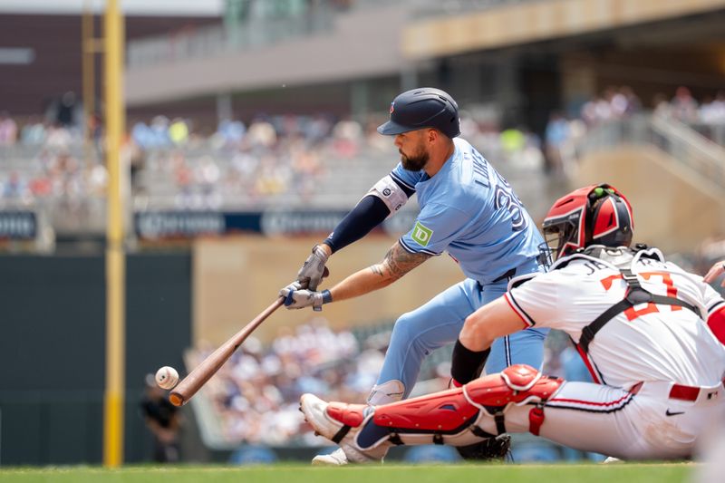Jun 7, 2025; Minneapolis, Minnesota, USA; Toronto Blue Jays outfielder Nathan Lukes (38) singles, scoring Toronto Blue Jays first base Vladimir Guerrero Jr. (27), off a pitch from Minnesota Twins starting pitcher Chris Paddack (20) in the first inning at Target Field. Mandatory Credit: Matt Blewett-Imagn Images