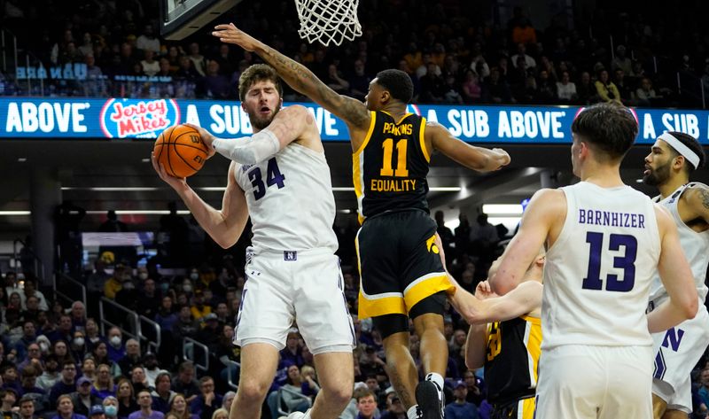 Feb 19, 2023; Evanston, Illinois, USA;Iowa Hawkeyes guard Tony Perkins (11) defends Northwestern Wildcats center Matthew Nicholson (34) during the second half at Welsh-Ryan Arena. Mandatory Credit: David Banks-USA TODAY Sports