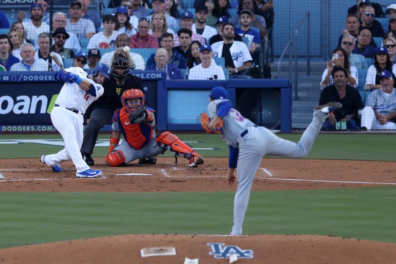 Oct 13, 2024; Los Angeles, California, USA; Los Angeles Dodgers third base Max Muncy (13) hits a two run single against the New York Mets in the first inning during game one of the NLCS for the 2024 MLB Playoffs at Dodger Stadium. Mandatory Credit: Jason Parkhurst-Imagn Images