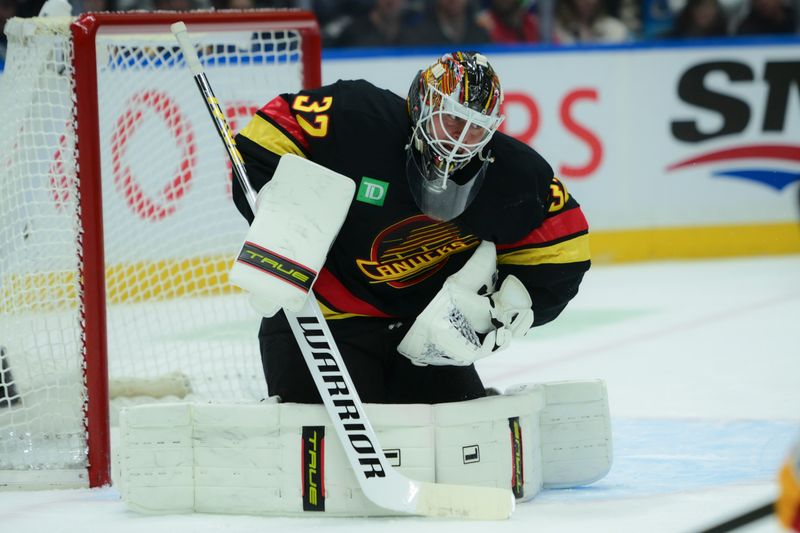 Nov 23, 2025; Vancouver, British Columbia, CAN;  Vancouver Canucks goaltender Kevin Lankinen (32) blocks a shot on net during the second period against the Calgary Flames at Rogers Arena. Mandatory Credit: Simon Fearn-Imagn Images