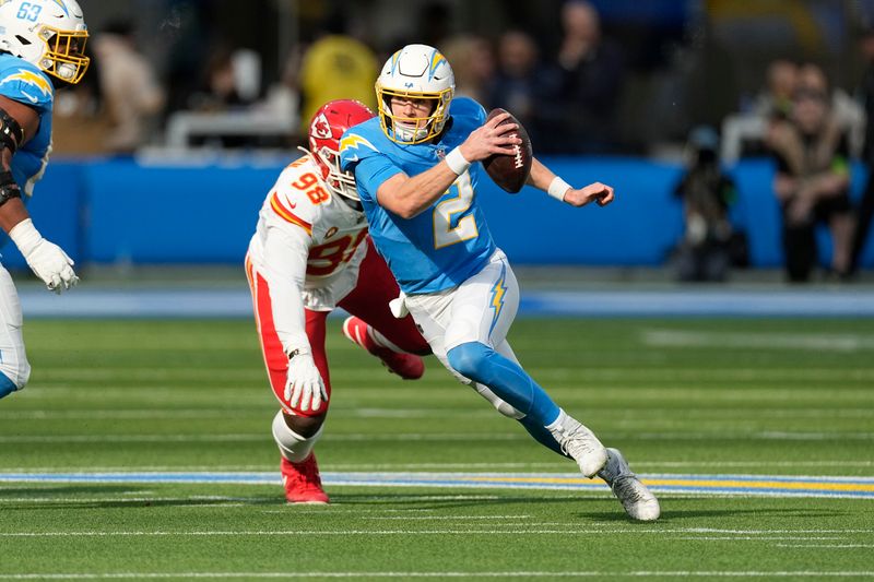 Los Angeles Chargers quarterback Easton Stick, right, scrambles away from Kansas City Chiefs defensive tackle Tershawn Wharton during the first half of an NFL football game, Sunday, Jan. 7, 2024, in Inglewood, Calif. (AP Photo/Mark J. Terrill)