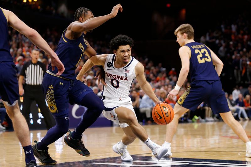 Feb 18, 2023; Charlottesville, Virginia, USA; Virginia Cavaliers guard Kihei Clark (0) controls the ball as Notre Dame Fighting Irish guard J.J. Starling (1) defends during the second half at John Paul Jones Arena. Mandatory Credit: Amber Searls-USA TODAY Sports