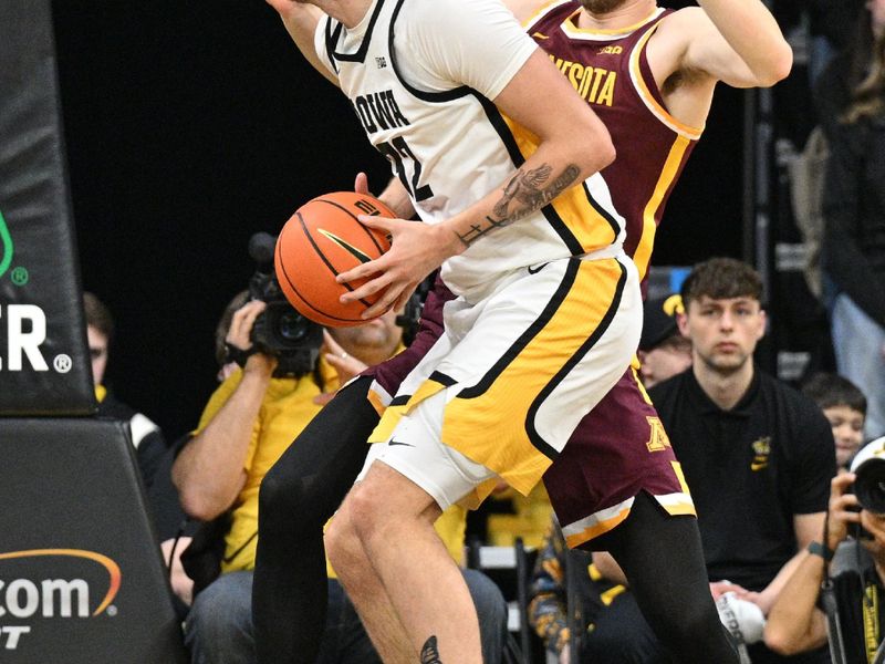 Feb 11, 2024; Iowa City, Iowa, USA; Iowa Hawkeyes forward Owen Freeman (32) goes to the basket as Minnesota Golden Gophers forward Parker Fox (23) defends during the first half at Carver-Hawkeye Arena. Mandatory Credit: Jeffrey Becker-USA TODAY Sports