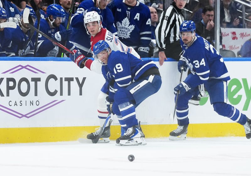Oct 8, 2025; Toronto, Ontario, CAN; Toronto Maple Leafs center Calle Jarnkrok (19) battles along the boards with Montreal Canadiens left wing Juraj Slafkovsky (20) during the third period at Scotiabank Arena. Mandatory Credit: Nick Turchiaro-Imagn Images