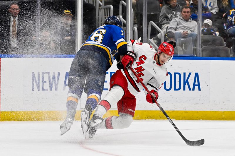 Apr 12, 2024; St. Louis, Missouri, USA;  Carolina Hurricanes center Sebastian Aho (20) is checked by St. Louis Blues center Zack Bolduc (76) during the third period at Enterprise Center. Mandatory Credit: Jeff Curry-USA TODAY Sports