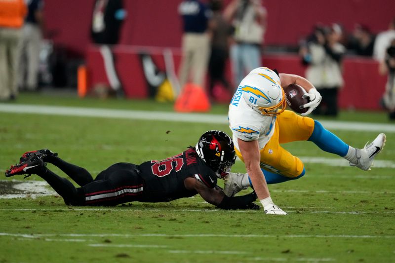 Los Angeles Chargers tight end Will Dissly (81) is tackled by Arizona Cardinals cornerback Max Melton (16) after catching a pass during the first half of an NFL football game, Monday, Oct. 21, 2024, in Glendale Ariz. (AP Photo/Matt York)