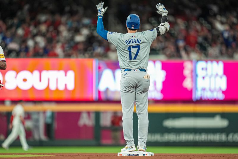 Sep 15, 2024; Cumberland, Georgia, USA; Los Angeles Dodgers designated hitter Shohei Ohtani (17) reacts after hitting a double to drive in a run against the Atlanta Braves during the seventh inning at Truist Park. Mandatory Credit: Dale Zanine-Imagn Images