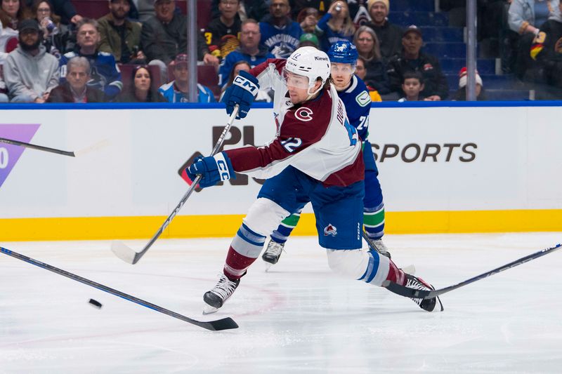 Mar 13, 2024; Vancouver, British Columbia, CAN; Colorado Avalanche forward Brandon Duhaime (12) shoots against the Vancouver Canucks in the second period at Rogers Arena. Mandatory Credit: Bob Frid-USA TODAY Sports