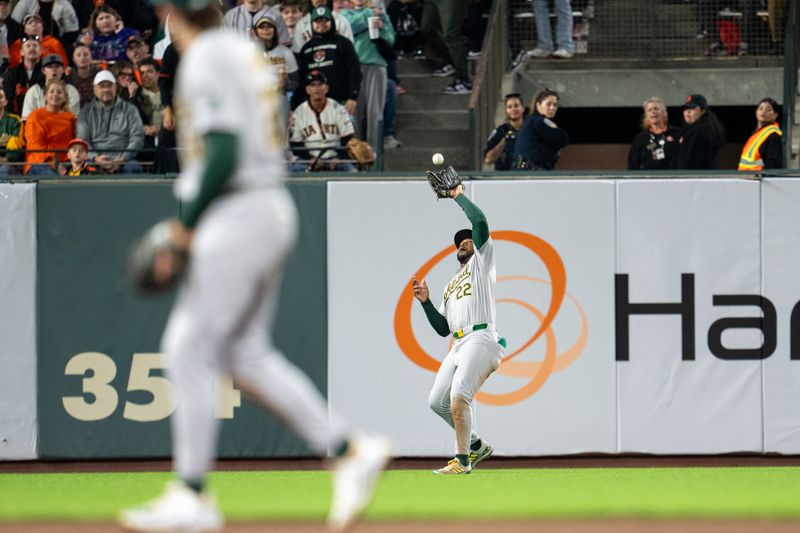 Jul 30, 2024; San Francisco, California, USA;  Oakland Athletics left fielder Miguel Andujar (22) fields a fly ball against the San Francisco Giants during the seventh inning at Oracle Park. Mandatory Credit: Neville E. Guard-USA TODAY Sports