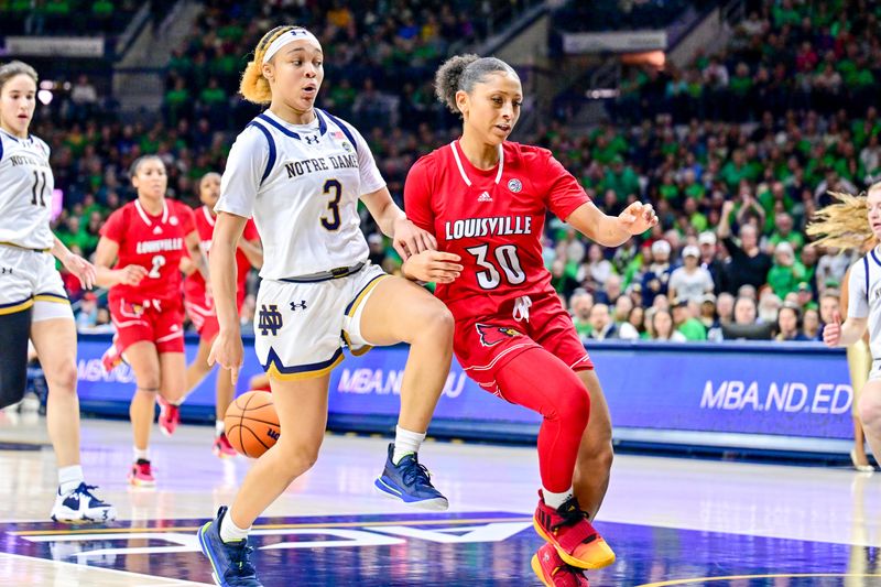 Mar 3, 2024; South Bend, Indiana, USA; Notre Dame Fighting Irish guard Hannah Hidalgo (3) makes a behind the back pass as Louisville Cardinals guard Jayda Curry (30) defends in the second half at the Purcell Pavilion. Mandatory Credit: Matt Cashore-USA TODAY Sports