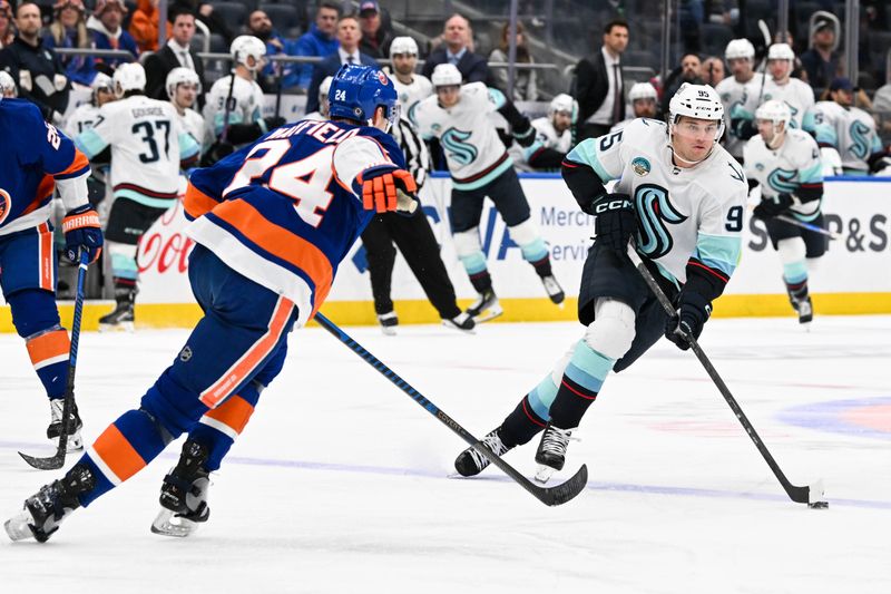 Feb 13, 2024; Elmont, New York, USA; Seattle Kraken left wing Andre Burakovsky (95) skates across the blue line defended by New York Islanders defenseman Scott Mayfield (24) during the third period at UBS Arena. Mandatory Credit: Dennis Schneidler-USA TODAY Sports