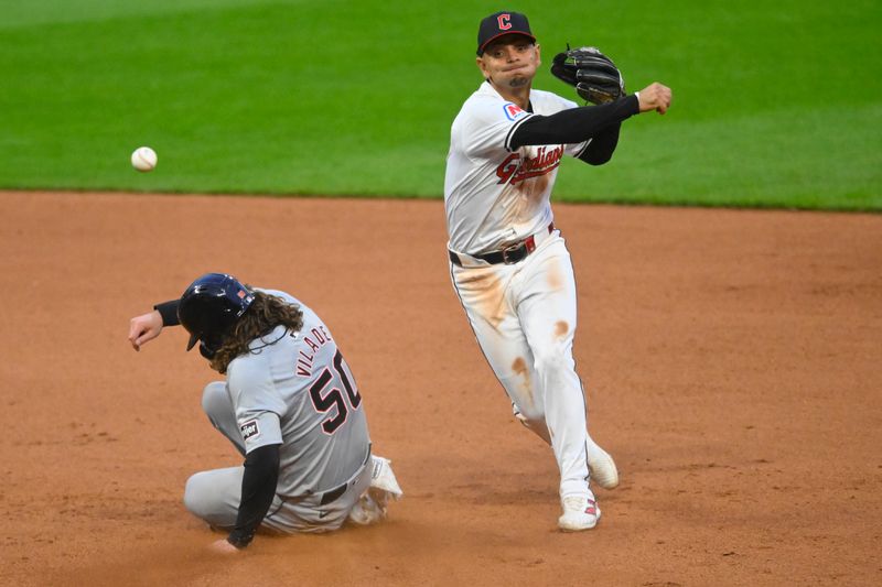 May 7, 2024; Cleveland, Ohio, USA; Cleveland Guardians second baseman Andres Gimenez (0) turns a double play against Detroit Tigers right fielder Ryan Vilade (50) in the seventh inning at Progressive Field. Mandatory Credit: David Richard-USA TODAY Sports