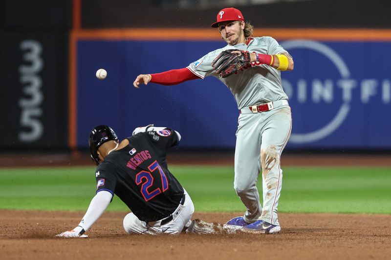 Sep 19, 2024; New York City, New York, USA;  Philadelphia Phillies second baseman Bryson Stott (5) throws past New York Mets third baseman Mark Vientos (27) to complete a double play in the third inning at Citi Field. Mandatory Credit: Wendell Cruz-Imagn Images