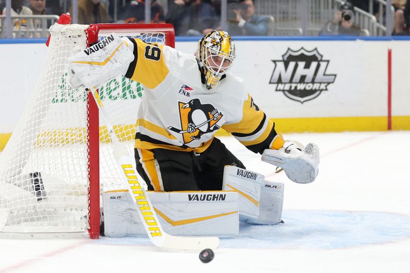 Nov 5, 2024; Elmont, New York, USA; Pittsburgh Penguins goaltender Alex Nedeljkovic (39) plays the puck against the New York Islanders during the second period at UBS Arena. Mandatory Credit: Brad Penner-Imagn Images