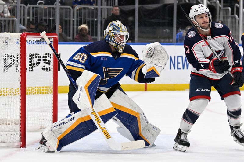 Jan 30, 2024; St. Louis, Missouri, USA; St. Louis Blues goaltender Jordan Binnington (50) defends the net from Columbus Blue Jackets right wing Justin Danforth (17) during the first period at Enterprise Center. Mandatory Credit: Jeff Le-USA TODAY Sports