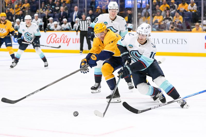 Oct 15, 2024; Nashville, Tennessee, USA;  Nashville Predators center Jonathan Marchessault (81) and Seattle Kraken center Matty Beniers (10) fight for the puck during the first period at Bridgestone Arena. Mandatory Credit: Steve Roberts-Imagn Images