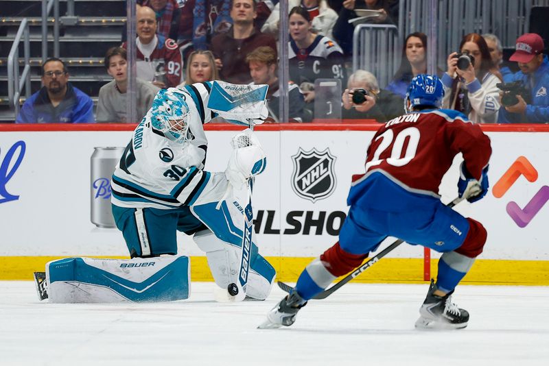 Feb 4, 2026; Denver, Colorado, USA; San Jose Sharks goaltender Yaroslav Askarov (30) plays the puck against Colorado Avalanche center Ross Colton (20) in the first period at Ball Arena. Mandatory Credit: Isaiah J. Downing-Imagn Images