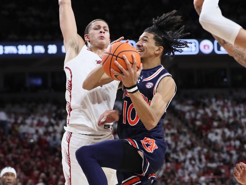 Jan 6, 2024; Fayetteville, Arkansas, USA; Auburn Tigers guard Chad Baker-Mazara (10) drives against Arkansas Razorbacks forward Trevon Brazile (2) during the first half at Bud Walton Arena. Mandatory Credit: Nelson Chenault-USA TODAY Sports