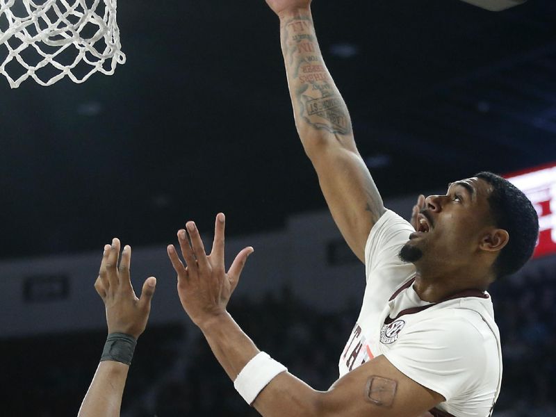 Feb 17, 2024; Starkville, Mississippi, USA; Mississippi State Bulldogs forward Tolu Smith (right) shoots the ball against the Arkansas Razorbacks during the first half at Humphrey Coliseum. Mandatory Credit: Petre Thomas-USA TODAY Sports