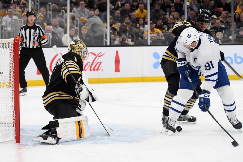 Apr 30, 2024; Boston, Massachusetts, USA; Boston Bruins defenseman Hampus Lindholm (27) and Toronto Maple Leafs center John Tavares (91) battle for the puck in front of goaltender Jeremy Swayman (1) during the second period in game five of the first round of the 2024 Stanley Cup Playoffs at TD Garden. Mandatory Credit: Bob DeChiara-USA TODAY Sports