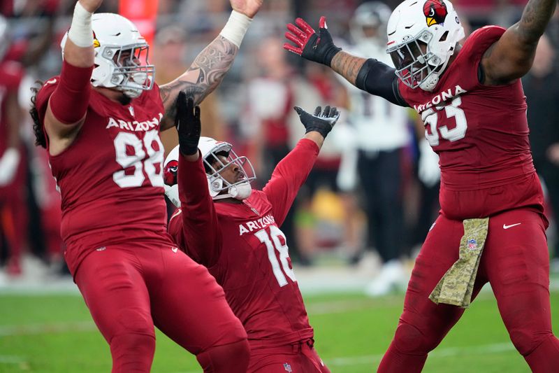 Arizona Cardinals defensive tackle Roy Lopez (98), linebacker BJ Ojulari (18), and defensive end Jonathan Ledbetter celebrate against the Atlanta Falcons during the first half of an NFL football game, Sunday, Nov. 12, 2023, in Glendale, Ariz. (AP Photo/Matt York)