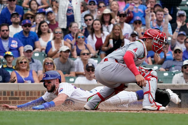 Jul 7, 2024; Chicago, Illinois, USA; Chicago Cubs third baseman Miles Mastrobuoni (20) is safe at home plate as Los Angeles Angels catcher Logan O'Hoppe (14) makes a late tag during the third inning at Wrigley Field. Mandatory Credit: David Banks-USA TODAY Sports