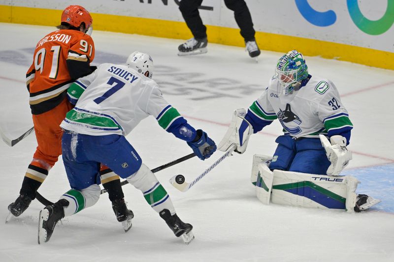 Nov 5, 2024; Anaheim, California, USA;Vancouver Canucks defenseman Carson Soucy (7) battle with Anaheim Ducks center Leo Carlsson (91) as Vancouver Canucks goaltender Kevin Lankinen (32) pokes the puck away from the goal in the first period at Honda Center. Mandatory Credit: Jayne Kamin-Oncea-Imagn Images