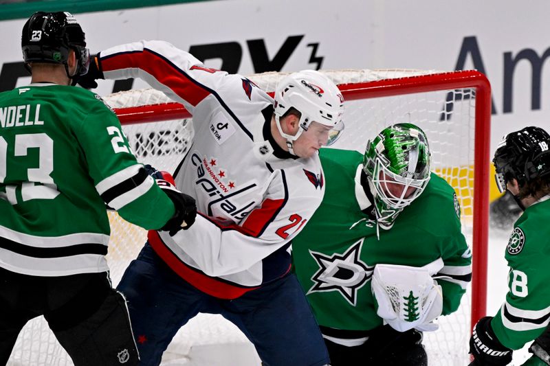 Oct 28, 2025; Dallas, Texas, USA; Dallas Stars goaltender Jake Oettinger (29) makes a glove save in front of Washington Capitals center Aliaksei Protas (21) during the second period at the American Airlines Center. Mandatory Credit: Jerome Miron-Imagn Images