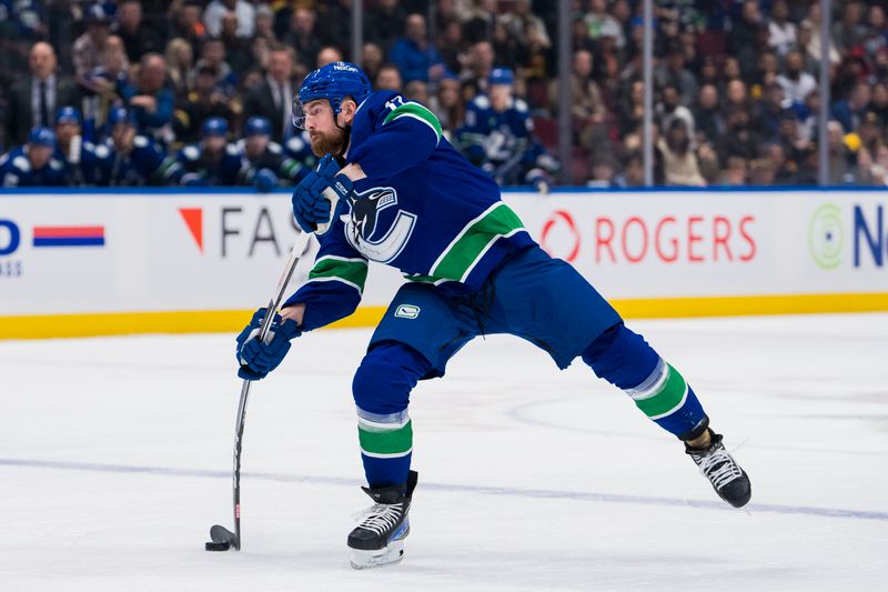 Dec 9, 2023; Vancouver, British Columbia, CAN; Vancouver Canucks defenseman Filip Hronek (17) shoots against the Carolina Hurricanes in the first period at Rogers Arena. Mandatory Credit: Bob Frid-USA TODAY Sports