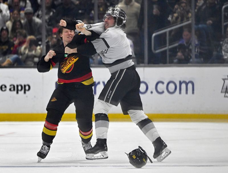 Apr 10, 2023; Los Angeles, California, USA;  Vancouver Canucks center Sheldon Dries (15) and Los Angeles Kings defenseman Sean Durzi (50) fight in the second period at Crypto.com Arena. Mandatory Credit: Jayne Kamin-Oncea-USA TODAY Sports