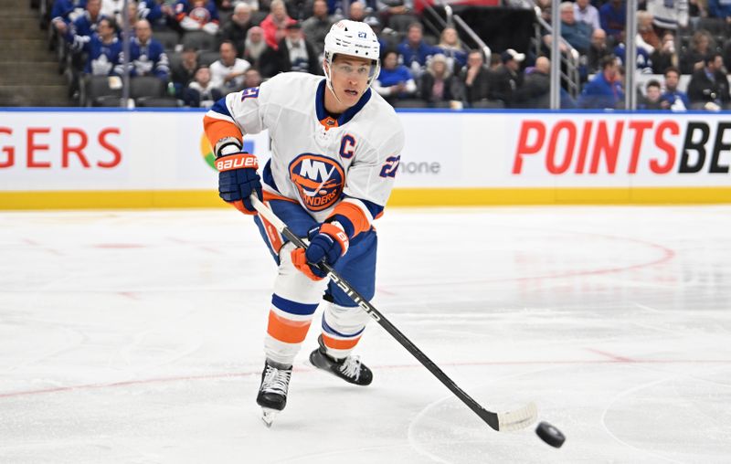 Feb 5, 2024; Toronto, Ontario, CAN;  New York Islanders forward Anders Lee (27) plays the puck against the Toronto Maple Leafs in the first period at Scotiabank Arena. Mandatory Credit: Dan Hamilton-USA TODAY Sports