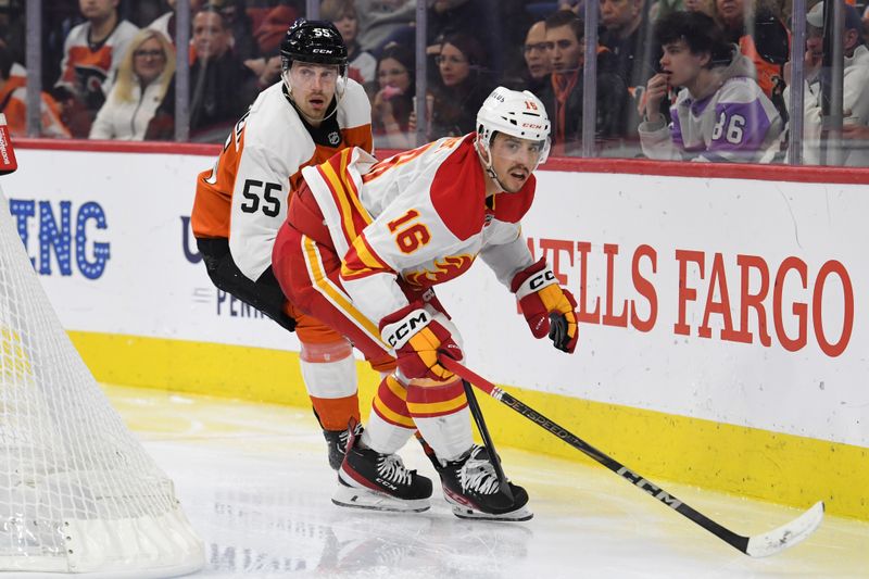 Mar 4, 2025; Philadelphia, Pennsylvania, USA; Philadelphia Flyers defenseman Rasmus Ristolainen (55) and Calgary Flames center Morgan Frost (16) during the second period at Wells Fargo Center. Mandatory Credit: Eric Hartline-Imagn Images