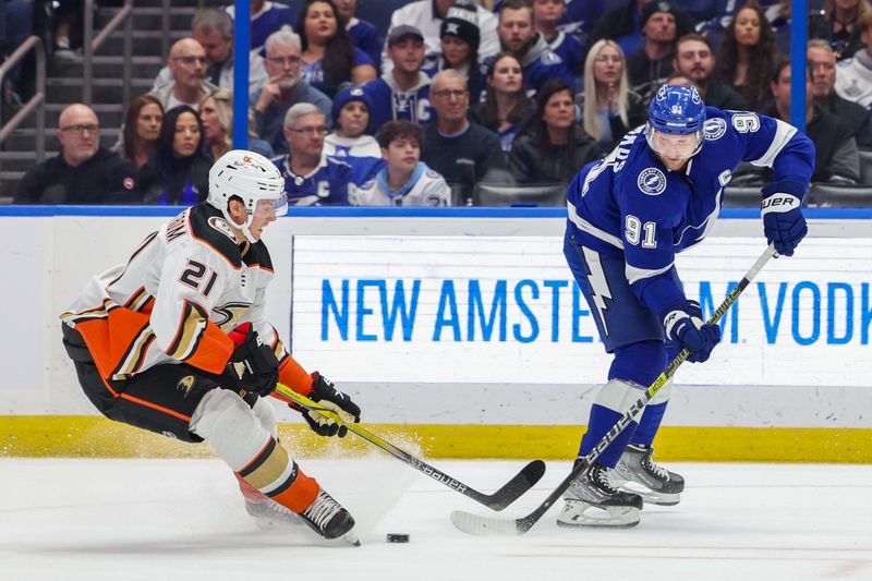 Jan 13, 2024; Tampa, Florida, USA;  Tampa Bay Lightning center Steven Stamkos (91) passes the puck past Anaheim Ducks center Isac Lundestrom (21) in the first period  at Amalie Arena. Mandatory Credit: Nathan Ray Seebeck-USA TODAY Sports