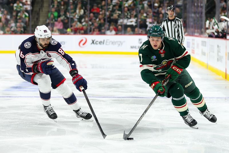 Oct 10, 2024; Saint Paul, Minnesota, USA; Minnesota Wild defenseman Brock Faber (7) skates with the puck as Columbus Blue Jackets right wing Kirill Marchenko (86) defends during the second period at Xcel Energy Center. Mandatory Credit: Matt Krohn-Imagn Images