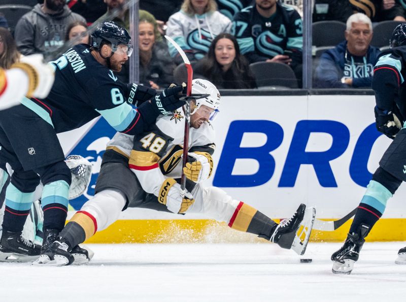 Oct 11, 2025; Seattle, Washington, USA; Vegas Golden Knights forward Tomas Hertl (48) and Seattle Kraken defenseman Adam Larsson (6) battle for the puck during the second period at Climate Pledge Arena. Mandatory Credit: Stephen Brashear-Imagn Images