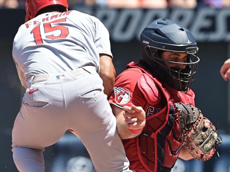 Jun 29, 2025; Cleveland, Ohio, USA; St. Louis Cardinals pinch hitter Jose Fermin (15) nearly collides with Cleveland Guardians catcher Austin Hedges (27) while scoring on a sacrifice fly during the eighth inning at Progressive Field. Mandatory Credit: Ken Blaze-Imagn Images