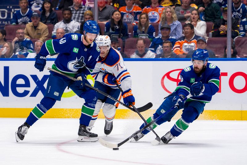 May 20, 2024; Vancouver, British Columbia, CAN; Edmonton Oilers forward Ryan McLeod (71) and Vancouver Canucks forward Elias Pettersson (40) watch forward Conor Garland (8) handle the puck during the third period in game seven of the second round of the 2024 Stanley Cup Playoffs at Rogers Arena. Mandatory Credit: Bob Frid-USA TODAY Sports