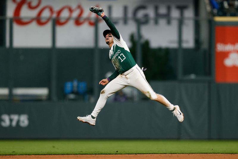 Apr 20, 2024; Denver, Colorado, USA; Colorado Rockies second baseman Alan Trejo (13) is unable to field a hit in the fifth inning against the Seattle Mariners at Coors Field. Mandatory Credit: Isaiah J. Downing-USA TODAY Sports