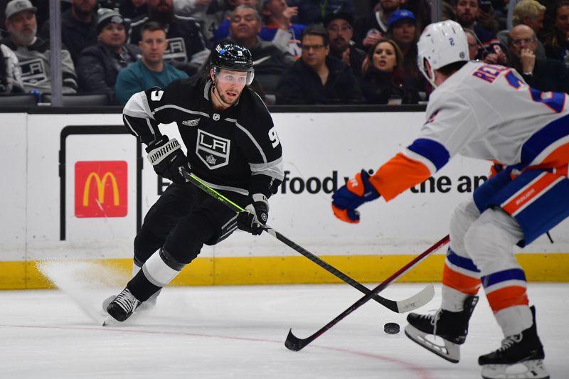 Mar 11, 2024; Los Angeles, California, USA; Los Angeles Kings right wing Adrian Kempe (9) moves the puck against New York Islanders defenseman Mike Reilly (2) during the second period at Crypto.com Arena. Mandatory Credit: Gary A. Vasquez-USA TODAY Sports