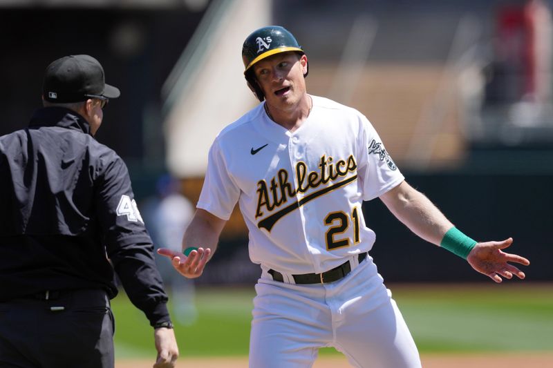 Apr 19, 2023; Oakland, California, USA; Oakland Athletics right fielder Conner Capel (21) argues with third base umpire Nick Mahrley (48) after being thrown out at third base on a steal attempt against the Chicago Cubs during the third inning at Oakland-Alameda County Coliseum. Mandatory Credit: Darren Yamashita-USA TODAY Sports