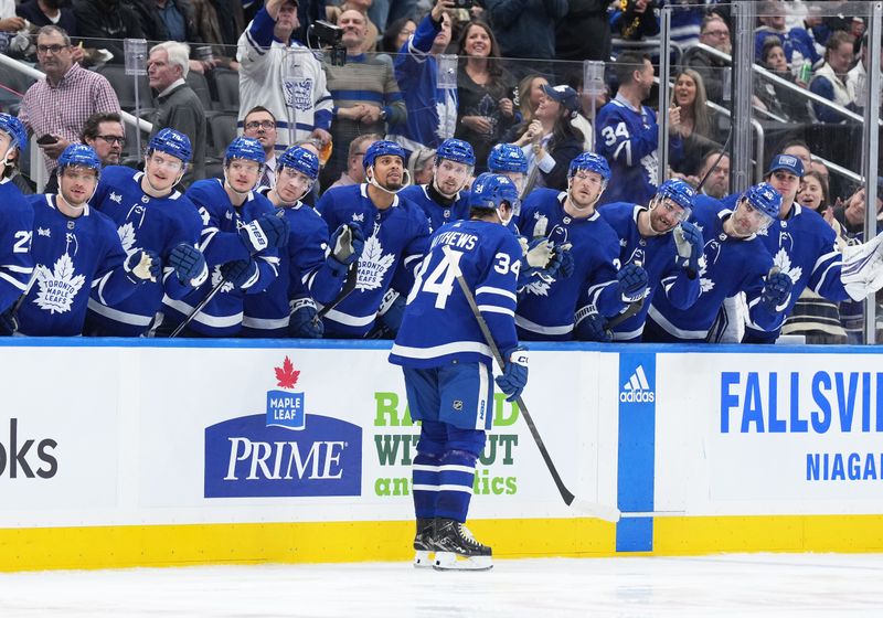 Apr 8, 2024; Toronto, Ontario, CAN; Toronto Maple Leafs center Auston Matthews (34) celebrates at the bench after scoring a goal against the Pittsburgh Penguins during the third period at Scotiabank Arena. Mandatory Credit: Nick Turchiaro-USA TODAY Sports