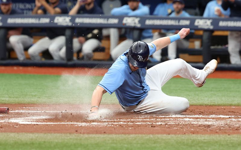 May 28, 2023; St. Petersburg, Florida, USA; Tampa Bay Rays right fielder Luke Raley (55) slides home to score a run during the second inning against the Los Angeles Dodgers at Tropicana Field. Mandatory Credit: Kim Klement-USA TODAY Sports