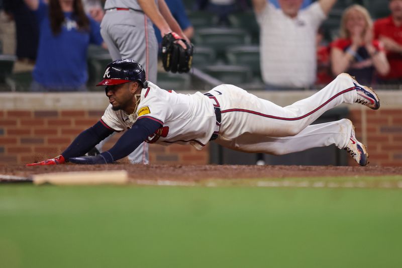 May 8, 2025; Atlanta, Georgia, USA; Atlanta Braves second baseman Ozzie Albies (1) slides safely to score the game-winning run against the Cincinnati Reds in the eleventh inning at Truist Park. Mandatory Credit: Brett Davis-Imagn Images
